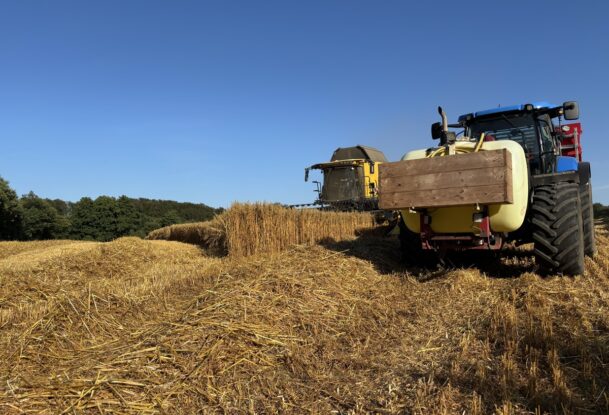 Un tracteur et une moissonneuse au travail dans un champ