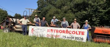 Des personnes dans un champ avec une banderole et du matériel argicole