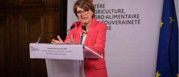 Une femme parle derrière un pupitre
